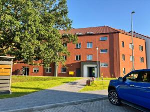 Niebieski samochód zaparkowany przed ceglanym budynkiem w obiekcie Apartament Przy Baryczy Milicz w mieście Milicz