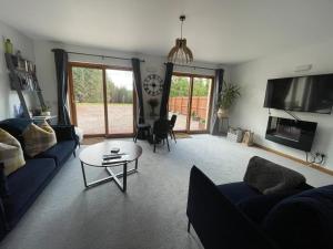 a living room with a couch and a table and a tv at Thistle Do Fort William in Fort William