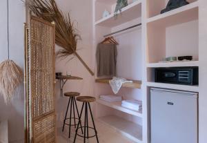 a room with a kitchen with stools and a microwave at Kynthia Hotel - Adults Only in Kalogria