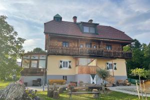 uma grande casa de madeira com um telhado de gambrel em Uriges Bauernhaus mit Blick auf Graz em Graz