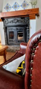 a leather chair in a living room with a fireplace at Casa Ines in Ricobayo