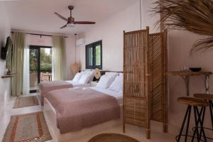 a bedroom with two beds and a fan at Kynthia Hotel - Adults Only in Kalogria