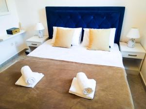 a bedroom with a large bed with towels on it at Apartment BayView in Donji Morinj