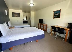 a hotel room with two beds and a desk at Lakeside Motel, Cabins and RV in Kingston