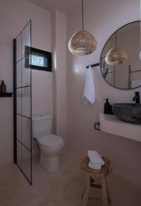 a bathroom with a toilet and a sink and a mirror at Kynthia Hotel - Adults Only in Kalogria