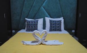 a bed with two towels in the shape of a heart at Rooms Filip in Bitola