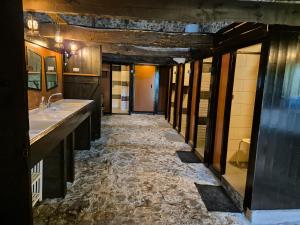 a bathroom with two sinks and a stone floor at wooden cabin in nature in Troche