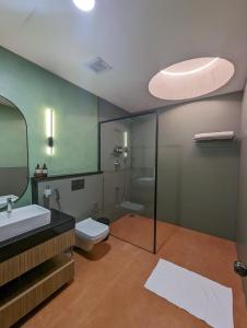 a bathroom with a toilet and a sink and a mirror at Isles Luxury Beach B&B in Mahabalipuram