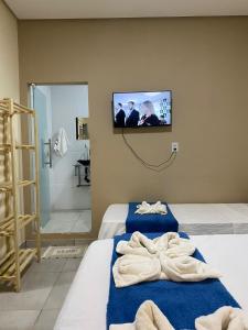 レンソイスにあるPousada Vista da Serra - Suzartのベッド2台、壁掛けテレビが備わる客室です。