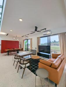 a living room with a couch and ping pong table at Isles Luxury Beach B&B in Mahabalipuram