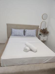 a white bed with a white towel on it at Dream house! in Qiryat Bialik