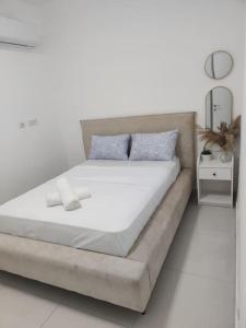 a bed in a white room with a white floor at Dream house! in Qiryat Bialik