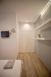 a bedroom with a bed and a tv on the wall at Loft de diseño junto a la dama de Elche in Valencia