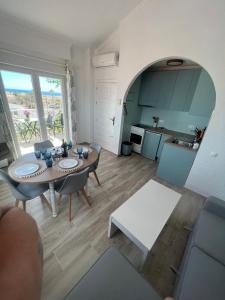 casa amor في توريفايجا: غرفة معيشة مع طاولة وكراسي ومطبخ