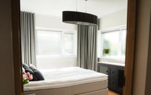 1 dormitorio con 1 cama y 2 ventanas en Private House with 4 Bedrooms and SAUNA near TARTU, 