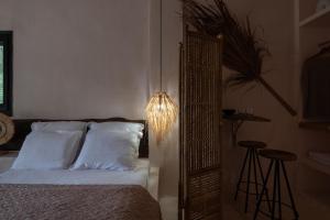 a bedroom with a bed with a mirror and a lamp at Kynthia Hotel - Adults Only in Kalogria