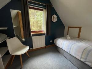 a bedroom with a bed and a chair and a window at Thistle Do Fort William in Fort William