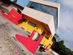 a colorful house with a red chair in front of it at Pôr-do-Sol Pousada in Penha