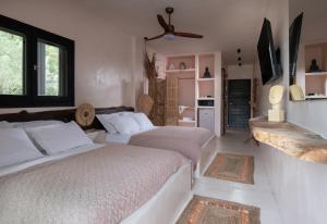 a bedroom with two beds and a living room at Kynthia Hotel - Adults Only in Kalogria
