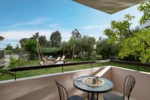 a patio with a table and chairs on a balcony at Kynthia Hotel - Adults Only in Kalogria