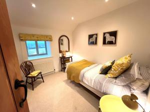um quarto com uma cama, uma cadeira e uma janela em 4 Bed in Masham 64329 em Grewelthorpe