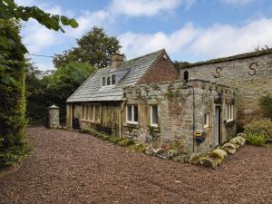 an old stone house in the middle of a driveway at 2 Bed in Alnwick 93093 in Edlingham