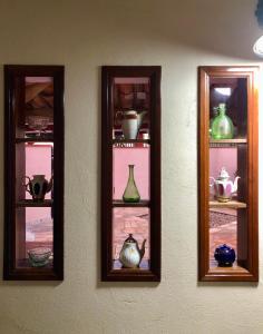 a wall with three glass shelves with vases on them at Gerais Loft in São Roque de Minas