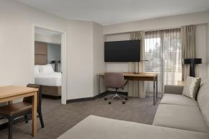 Habitación de hotel con cama y escritorio con TV. en Residence Inn Palo Alto Los Altos, en Palo Alto