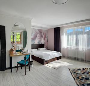 Schlafzimmer mit einem Bett, einem Schreibtisch und einem Spiegel in der Unterkunft Готель-ресторан Два Леви in Slawske