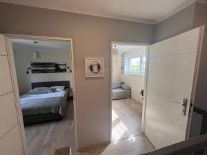 a bedroom with a bed and a door with a mirror at Nemo - apartament, domek w Gaskach in Gąski