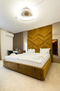 - une chambre avec un grand lit et une grande tête de lit en bois dans l'établissement Wanderer Sighisoara, à Sighişoara