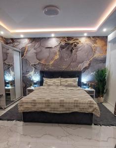 1 dormitorio con 1 cama grande y pared de piedra en GOLD APARTMANI, en Prokuplje