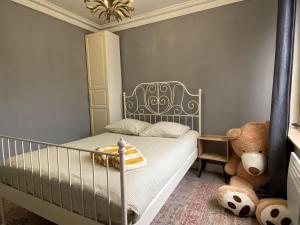 L'appartement des Champs Elysées في باريس: غرفة نوم مع سرير أطفال ودب