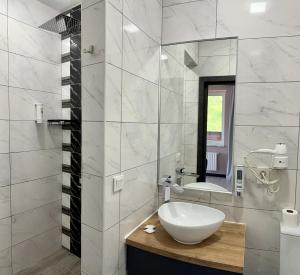 a white bathroom with a sink and a mirror at Готель-ресторан Два Леви in Slavske