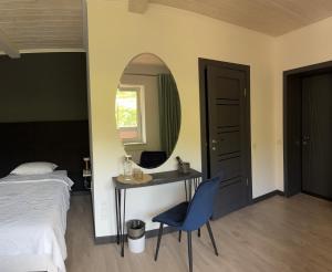 Schlafzimmer mit einem Bett, einem Tisch und einem Spiegel in der Unterkunft Готель-ресторан Два Леви in Slawske