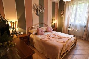 a bedroom with a bed with pink sheets and a table at L'Oasi tra mare e monti in Lerici