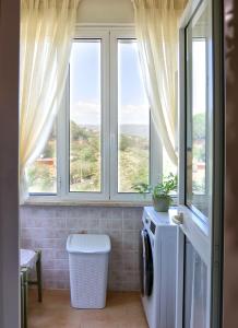 a bathroom with two windows and a washing machine at L'Oasi tra mare e monti in Lerici