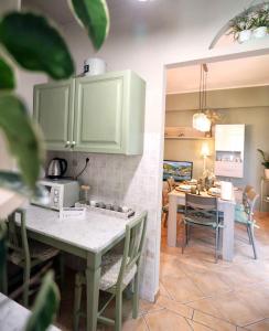 a kitchen with green cabinets and a table with chairs at L'Oasi tra mare e monti in Lerici