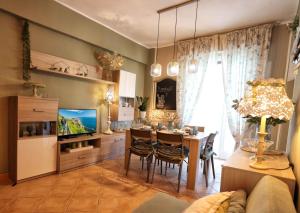 a living room with a dining table and a television at L'Oasi tra mare e monti in Lerici