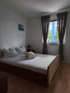a bedroom with a large bed with a window at Apartmani Barešić in Podgora