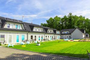 a large house with a green lawn in front of it at Przystań Dziwnówek in Dziwnówek