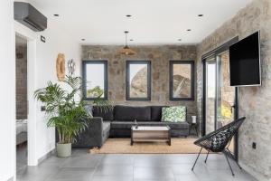 a living room with a couch and a tv at Mykonos Cottage in Ano Mera