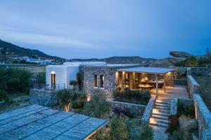 a stone house with a table and a patio at Mykonos Cottage in Ano Mera