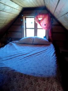 łóżko w pokoju z oknem w obiekcie Romantiline saunamaja Pädaste lahe ääres w mieście Pädaste