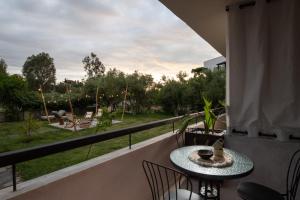 a balcony with a table and chairs and a view of a park at Kynthia Hotel - Adults Only in Kalogria