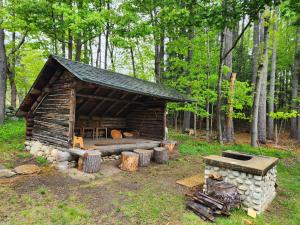 a log cabin with a fireplace in the woods at Trails End Inn in Keene Valley