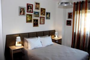 ein Schlafzimmer mit einem Bett mit Bildern an der Wand in der Unterkunft Casa do Artista in Vila Verde