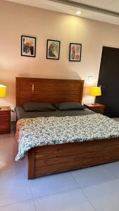 una camera da letto con un grande letto in legno con due lampade di House Of Wabi Sabi a Rawalpindi