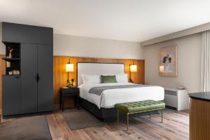 Un dormitorio con una cama grande y un taburete verde en The Watershed - Formerly Hotel Zero Degrees en Norwalk