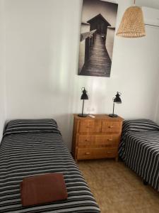 um quarto com duas camas e uma foto na parede em PAULA em Riumar